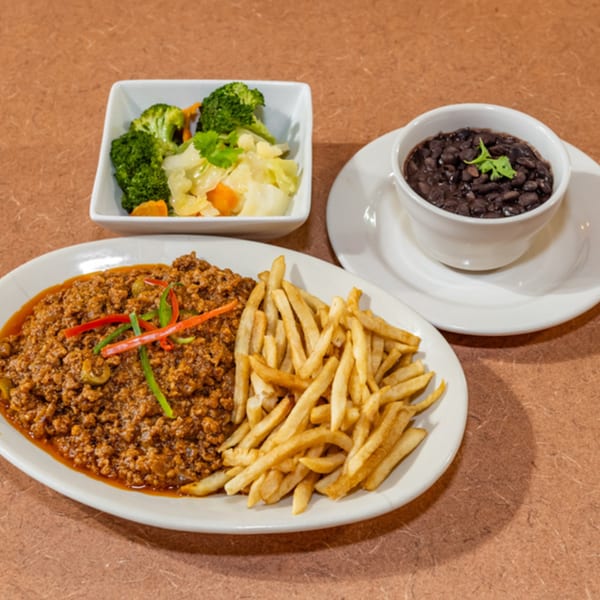 Cuban Diner's picadillo with fries, a side of steamed vegetables, and a bowl of black beans.